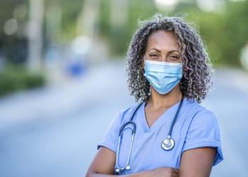 Portrait of an African American nurse wearing a protective face mask to avoid the transfer of germs during the COVID-19 outbreak.